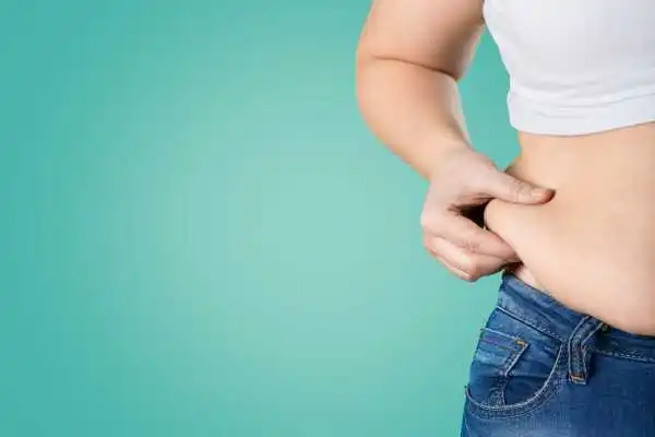 Image of woman pinching her love handles to show weight gain Rotherham